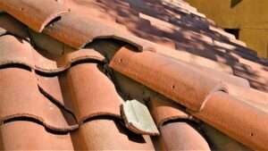 Cracked ridge tile on a residential roof—early sign of potential leaks, underlayment exposure, or structural stress on tile roofing