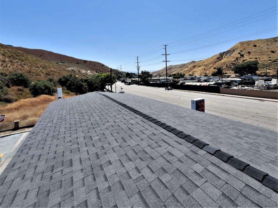 Completed second-layer Malarkey “Moonlit Black” shingles on gas station space frame in Canyon Country—clean, durable finish