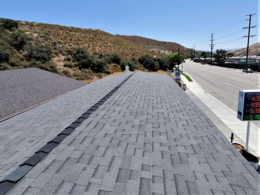 Completed second-layer Malarkey “Moonlit Black” shingles on gas station space frame in Canyon Country—clean, durable finish