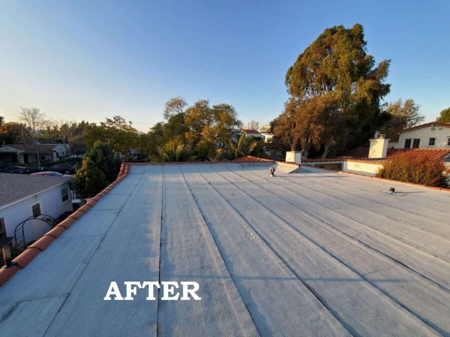 Completed second-layer modified bitumen roof with silicone sealant applied beneath existing solar panels in Los Angeles, CA