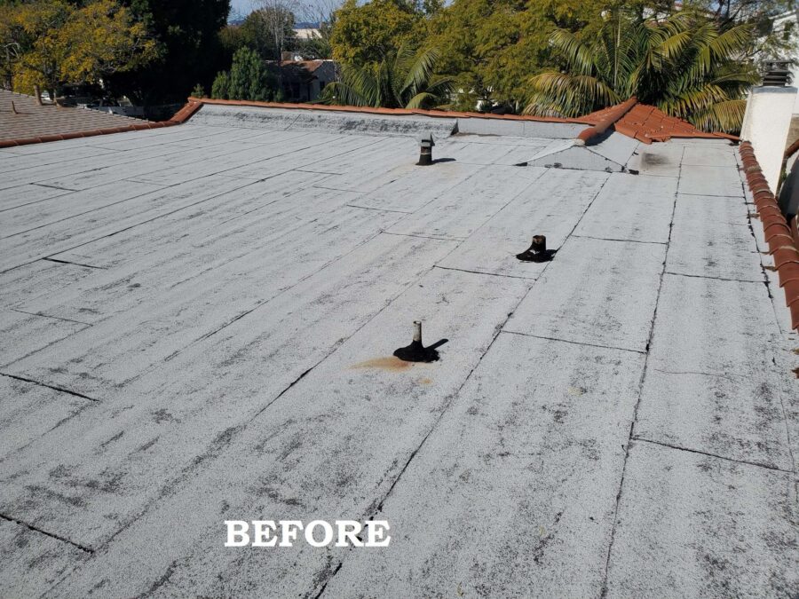 Flat roof in Los Angeles before second-layer modified bitumen and silicone sealing beneath solar panels—showing worn surface and prep stage