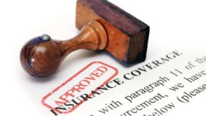 Home insurance approval stamp on roof claim paperwork—symbolizing successful roof replacement coverage approval